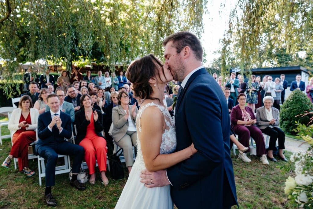 eerste kus tijdens persoonlijke ceremonie onder de wilgenboom