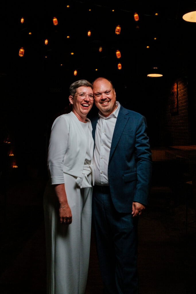 Bruidspaar onder hemel van bierflesjes met lichtjes in