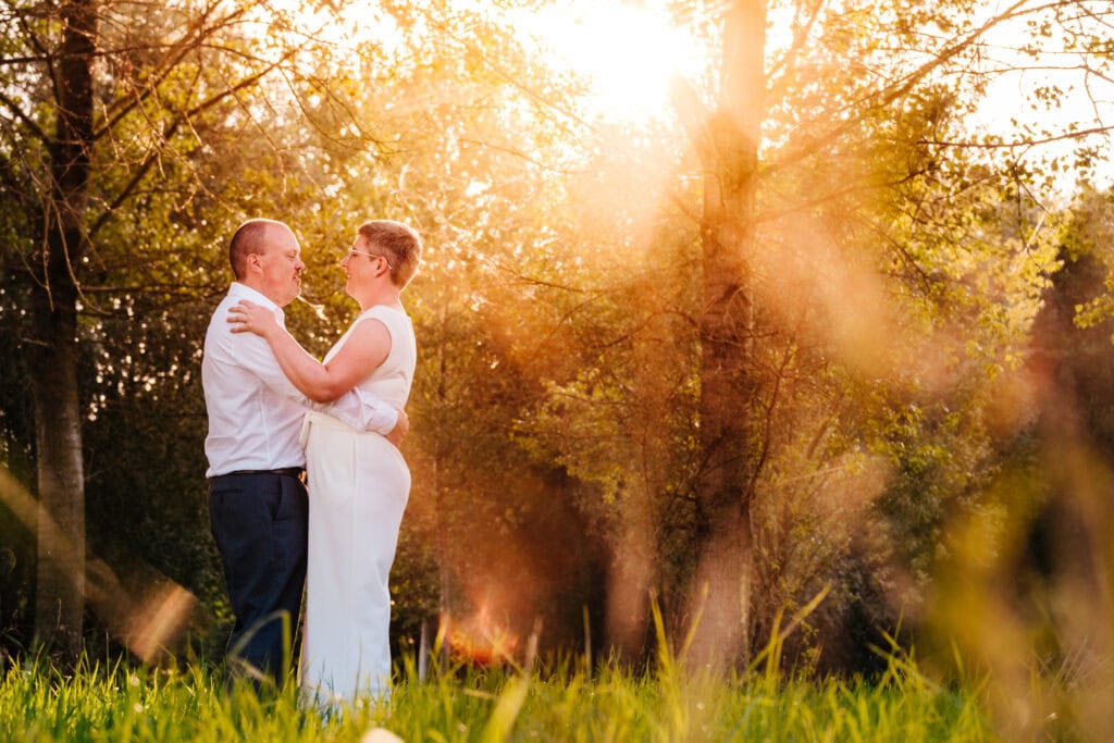 Bruidspaar in het bos bij ondergaande zon