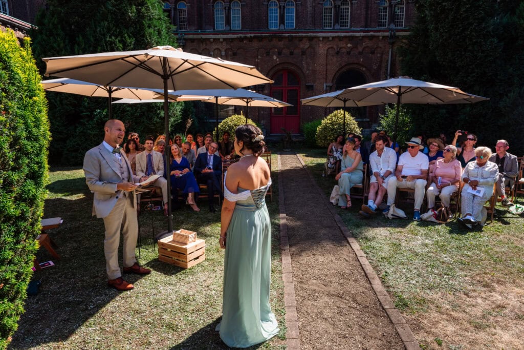 Huwelijk ceremonie abdij van Keizersberg Leuven, geloften door de bruidegom in stralende zon buiten in de binnentuin